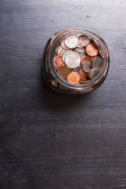 istock Jar of coins with dollar bills on the side 1126850511