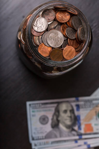 istock Jar of coins with dollar bills on the side 1126850652