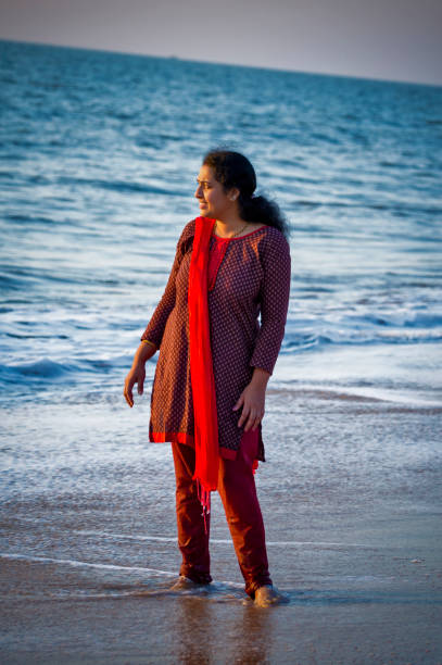 istock young Indian woman standing in beach 1126851279