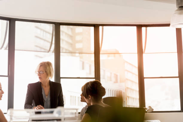 istock Mature female manager discussing with colleagues 1126852147