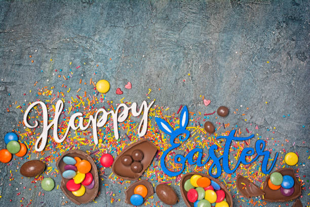 istock Top view on bright text of happy easter with chocolate traditional eggs, bunny and sprinkles 1126855565