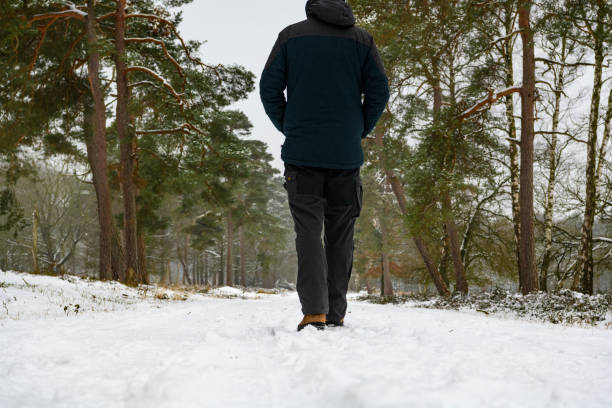 istock Man walking in a snowy forest with pine trees in the winter landscape 1126860065