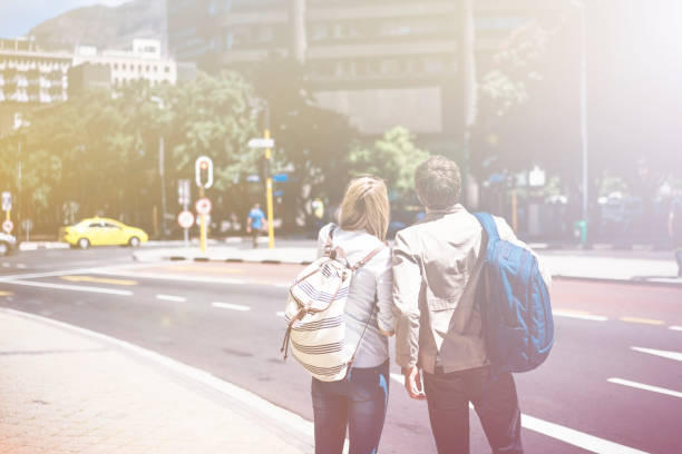 istock Rear view of backpackers standing on sidewalk 1126861078