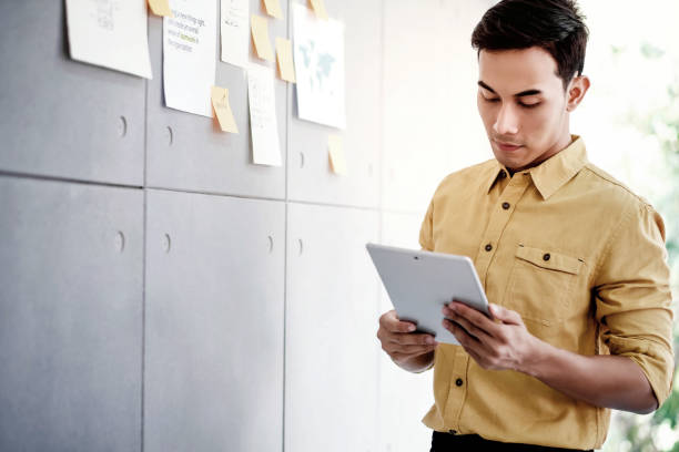 istock Young Asain Businessman Working on Digital Tablet in Office Meeting Room. Man Analyzing Data Plans and Project 1126861461