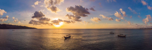 伝統的なバリ式ボート ドローンからバリ、インドネシアの写真の夕日ジンバランビーチのジュクン - jukung ストックフォトと画像