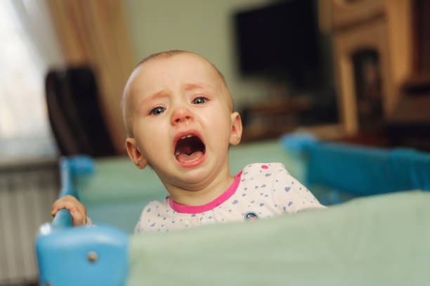 istock tearful child standing in playpen 1126867252