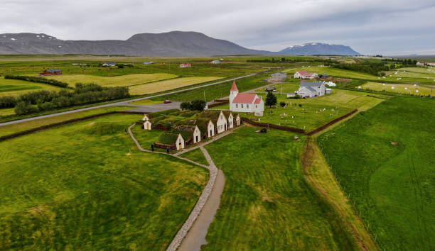 Aerial view of the historical Glaumbaer turf farm, Varmahlid, Iceland Aerial view of the historical Glaumbaer turf farm, museum, church, cemetery and surrounding green meadows, Varmahlid, Iceland. Panoramic landscape shot by drone camera. sod roof stock pictures, royalty-free photos & images