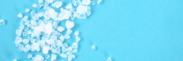istock Crystals of large sea salt and dill on a blue table. 1126867668