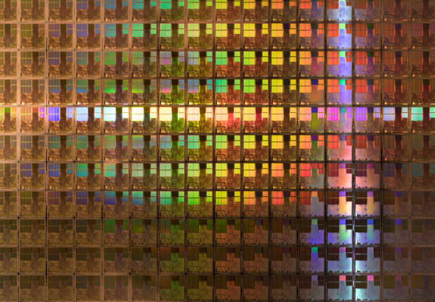 Silicon wafer with computer chips, light rays with rainbows patterns stock photo