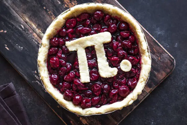 Pi Day Cherry Pie - making homemade traditional Cherry Pie with Pi sign for March 14th holiday, close up.