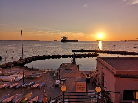 Sunset view of the sea nearby with Castello Aragonese, also called called Castel Sant'Angelo in Taranto, Italy