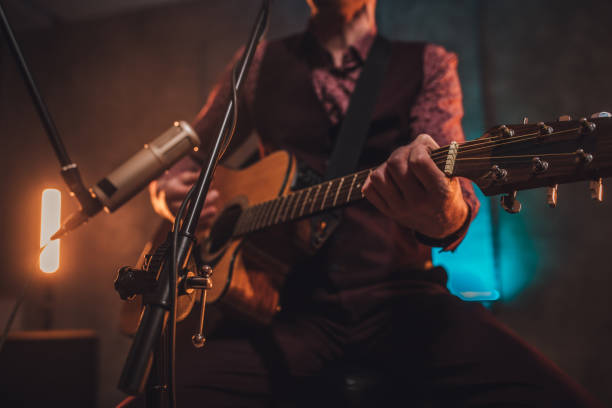 istock Musician singing and playing acoustic guitar in studio 1126873794