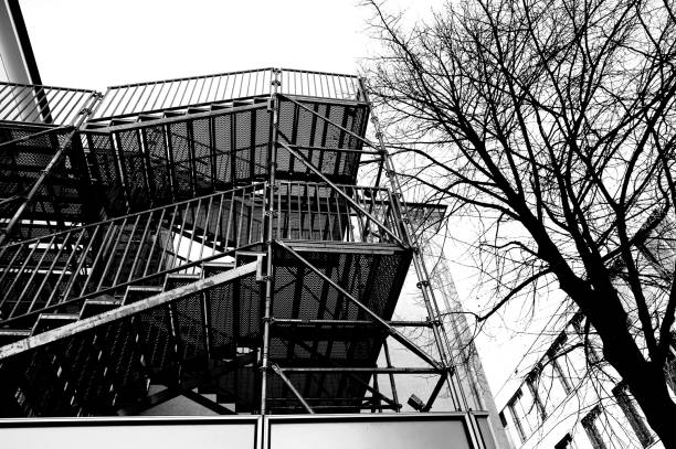 istock External staircase made of steel next to bare tree in black and white and steep perspective 1126875821