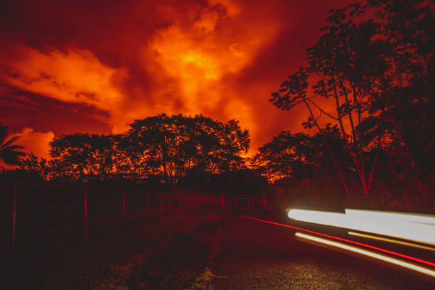 Forest Night Illuminated by Erupting Volcano The night sky glowing red from the Kilauea lava flow. pele stock pictures, royalty-free photos & images