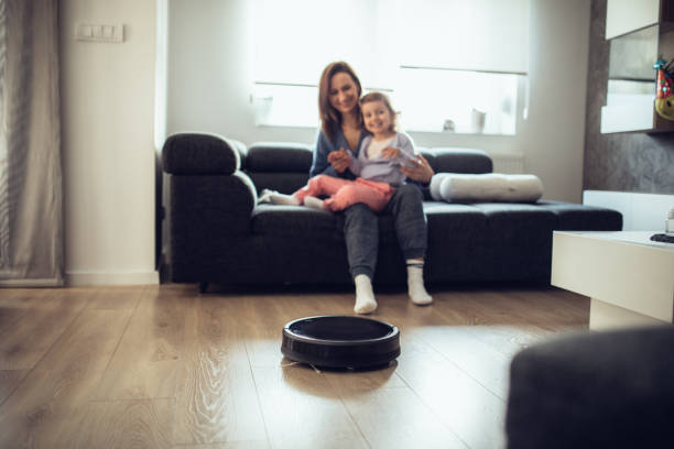 istock Robotic Vacuum Cleaner Cleaning While Mother and Daughter Relaxing Together 1126877922