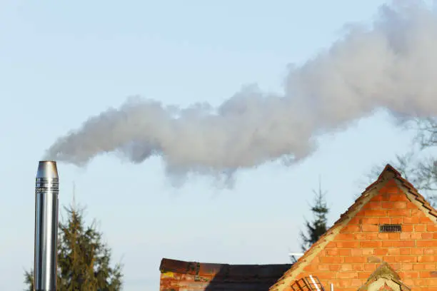 Domestic biomass chimney emitting smoke and pollutants into the environment