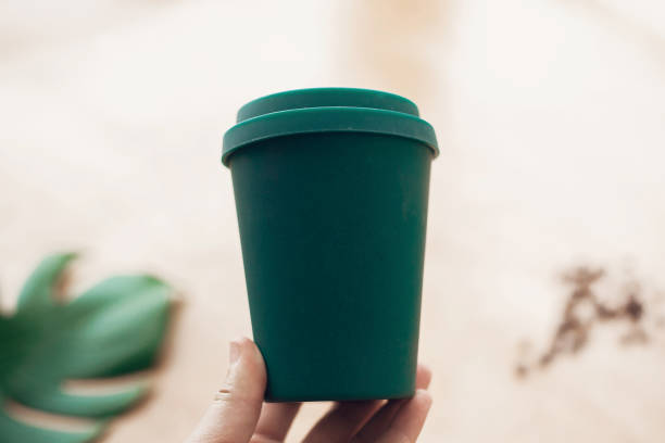 istock Coffee cup from bamboo fiber, zero waste concept. Ban single use plastic. Take away coffee in your cup. Sustainable lifestyle. Hand holding eco coffee cup on wooden background. 1126877988