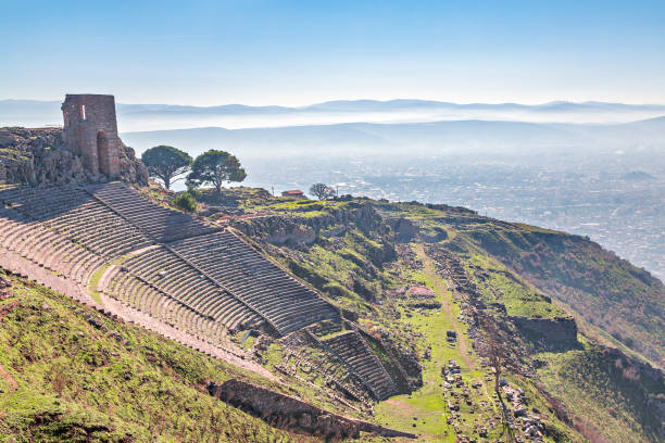 amphithéâtre romain dans les ruines de la ville antique de pergame, également appelée pergame avec les montagnes en arrière-plan, izmir, turquie. - bergama photos et images de collection