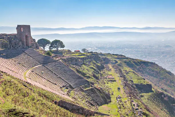 Photo of Roman amphitheater in the ruins of the ancient city of Pergamum known also as Pergamon with mountains in the background, Izmir, Turkey.