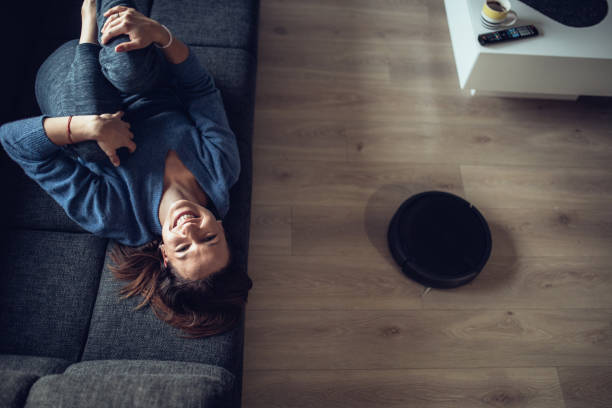 istock Happy Young Woman Using Robotic Cleaner 1126878177