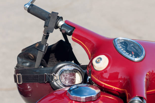 istock old model's motorcycle, red with chrome elements, retro helmet on the steering wheel 1126878458