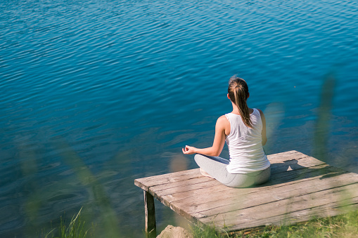 Woman doing some meditation at the water