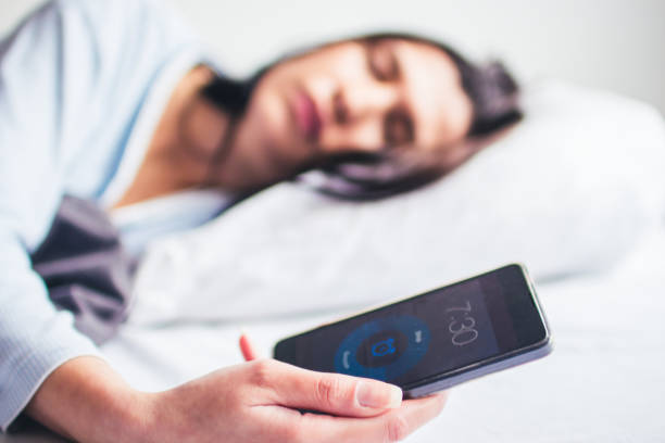 istock Woman Sleeping On Bed With Alarm On Mobile Phone 1126882396
