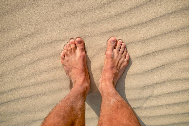 istock male legs on the reception sandy coast 1126882406