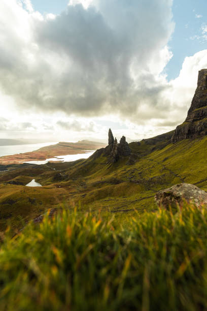 istock Old Man of Storr with grass foreground and the sun bursting through dramatic clouds during autumn (Isle of Skye, Scotland, United Kingdom) 1126883093