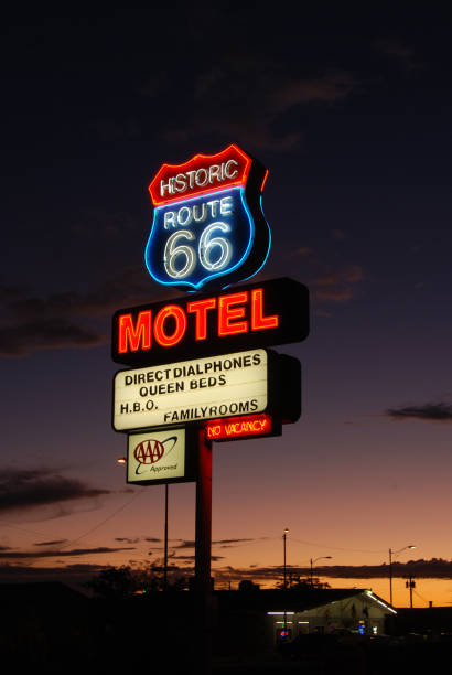 Old motel sign along historic route 66 against a blue sky.
