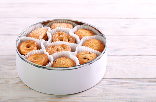 Tin full of butter cookies on wooden background