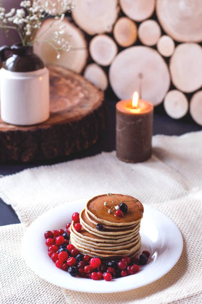 istock A stack of pancakes with blueberries and cranberries on a white plate. 1126888597