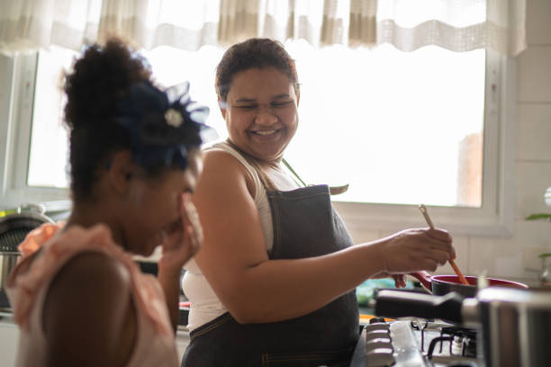 Young girl cooking with her mother Domestic Life iberian ethnicity stock pictures, royalty-free photos & images