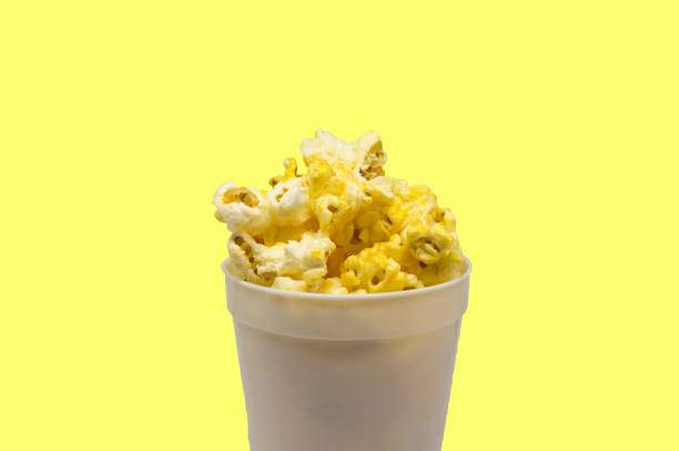 istock Popcorn in a white glass on a light yellow background. 1126891330