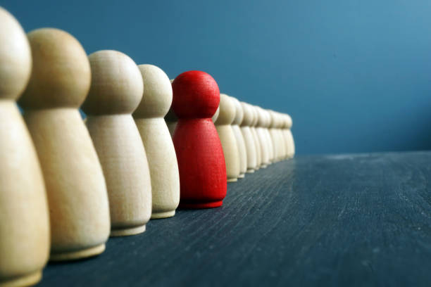 istock Leadership development. Line of wooden figurines with red one. 1126892385