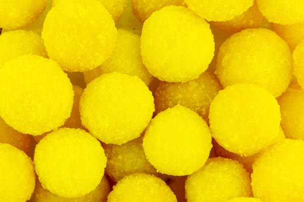 istock yellow bright sunny candy round delicious background dragee base backdrop close-up 1126892627