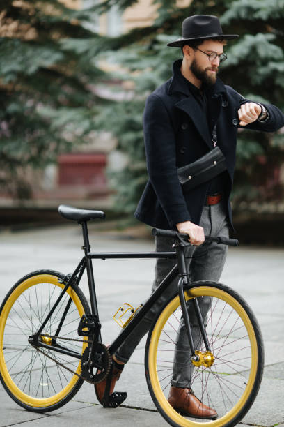 istock Handsome hipster bearded man enjoying a bicycle ride and checking time on his watch. 1126896314