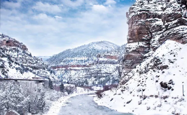 Winter mountain scenery. Freezing river flowing along snow capped mountains. Glenwood Canyon, Glenwood Springs, Colorado, USA.