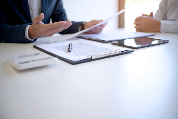 istock Sales manager giving advice application form document, considering mortgage loan offer for car and house insurance. 1126898750