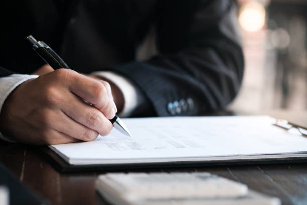istock Businessman analyzing investment charts and pressing calculator buttons over documents. Accounting Concept. 1126898798