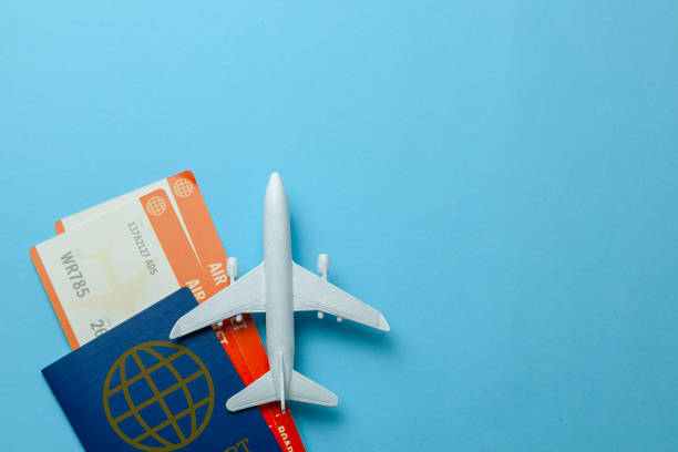 istock Tickets for plane and passport with model of passenger plane on blue background. Copy space for text. 1126901232