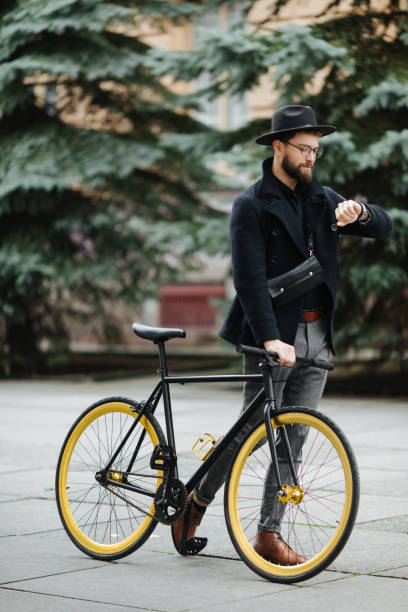 istock Handsome hipster bearded man enjoying a bicycle ride and checking time on his watch. 1126901784