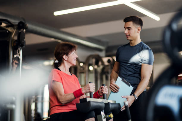 istock A female senior with a young trainer doing strength workout exercise in gym. 1126904139