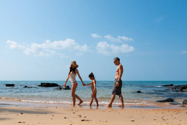 Father, mother and daughter play on the beach Father, mother and daughter play on the beach family beach vacations travel stock pictures, royalty-free photos & images