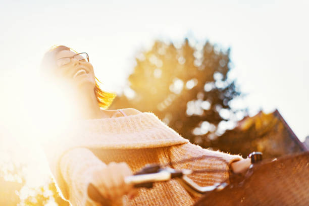 Young cheerful woman riding a bike on a sunny spring day.