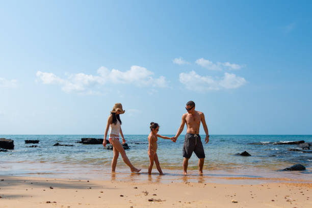 istock Father, mother and daughter play on the beach 1126906161