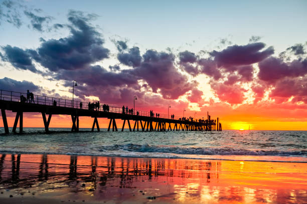 istock Iconic Glenelg jetty with people silhouettes at sunset 1126908369