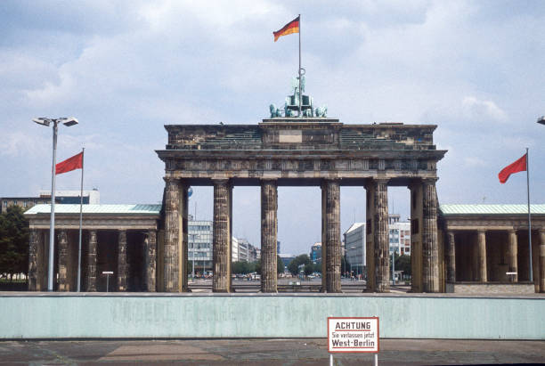 historisches bild vom juli 1980: ein blick von west-berlin über die berliner mauer bis zum brandenburger tor und ost-berlin. schild mit "vorsicht: sie verlassen west-berlin" im vordergrund. gescanntes dia. - brandenburger tor stock-fotos und bilder