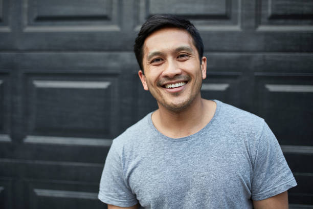 istock Portrait of smiling man against wall in backyard 1126908770