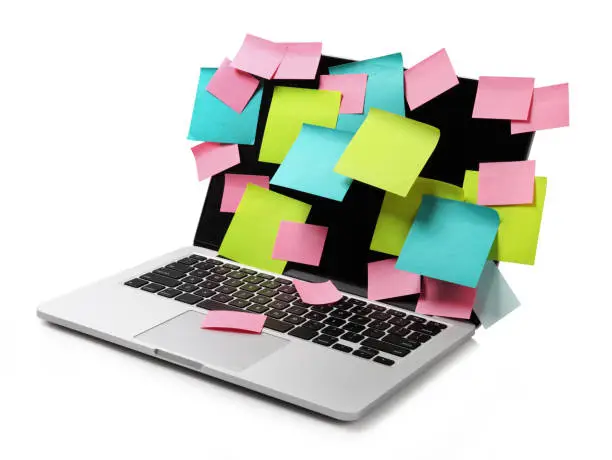 Photo of Image of laptop full of colorful sticky notes reminders on screen isolated on white. Work overload concept image